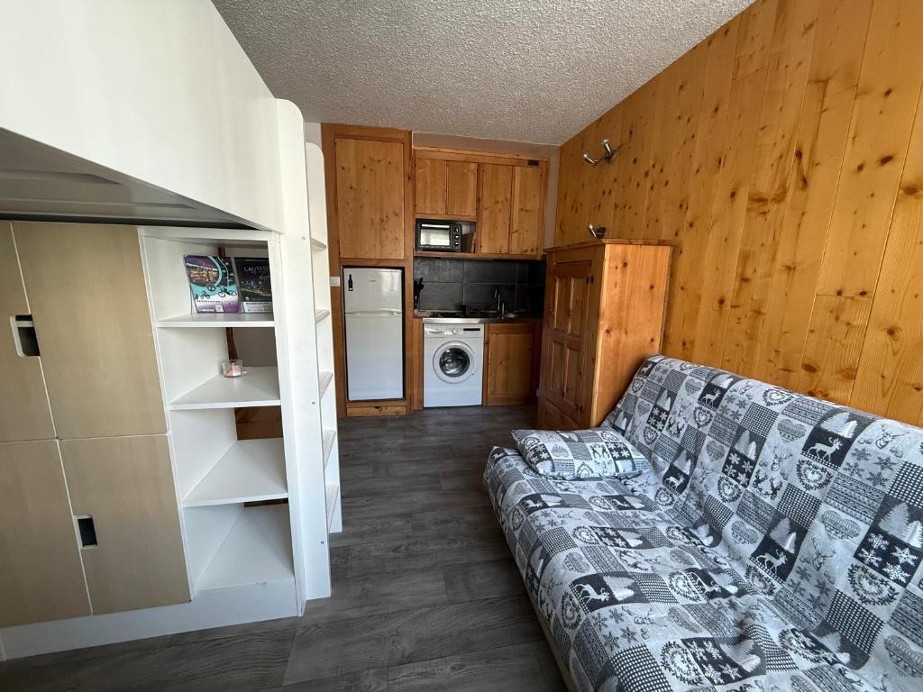 a living room with a couch and a kitchen at Location studio à Serre Chevalier 1350 in Saint-Chaffrey