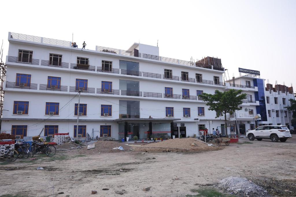 a large white building with blue windows at New Awadhesh Singh Hotel in Chauri
