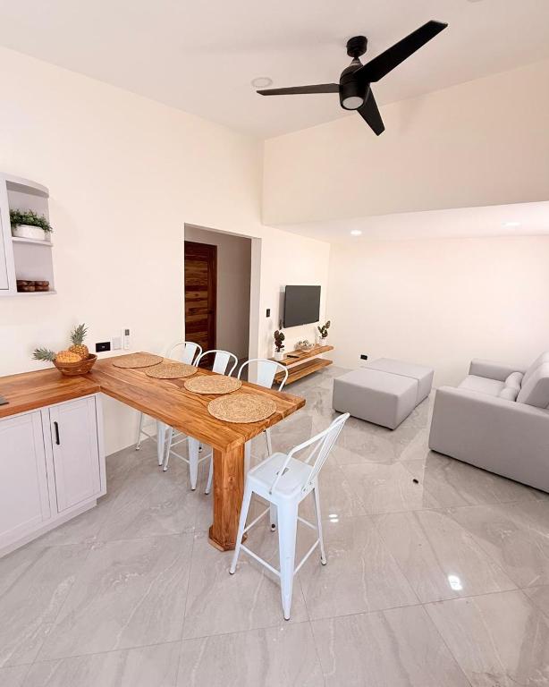 a kitchen and living room with a wooden table and chairs at Brianne's Place in Playa hermosa