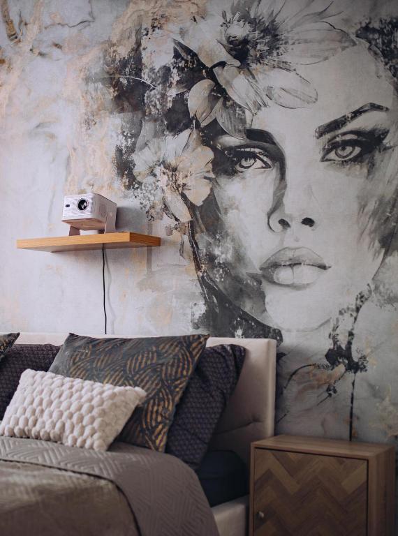 a mural of a woman with flowers on a wall at Apartament Panorama Boho in Mława