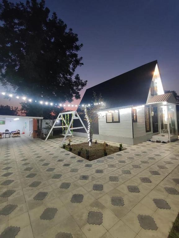 ein Haus mit einem Innenhof, in dem ein Baum steht und Lichterketten angebracht sind in der Unterkunft Lenkeran Aframe in Länkäran