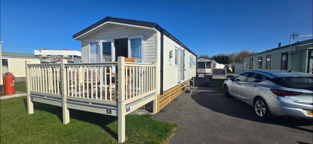 a tiny house with a car parked next to it at Graham's Dream in Heysham