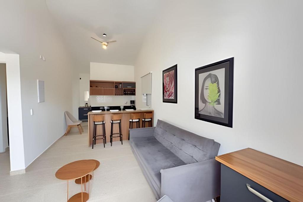 a living room and kitchen with a couch and a table at Studio VI até 7 pessoas em Juquehy in São Sebastião