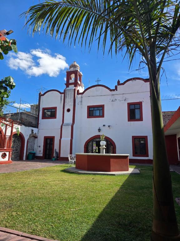 a building with a palm tree in front of it at Hotel Casa del virrey Atlixco in Atlixco