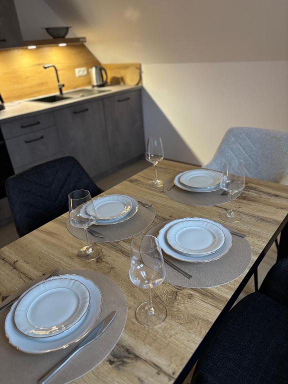 a wooden table with plates and wine glasses on it at Kiefer in Nortrup