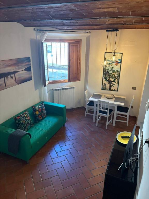 a living room with a green couch and a table at Lovely Stay in Sesto Fiorentino