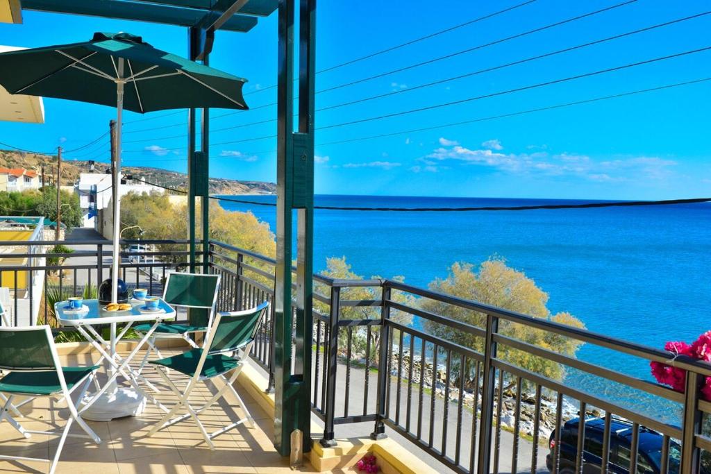 a balcony with a table and chairs and the ocean at Villa Eli Keratokampos in Kastrí