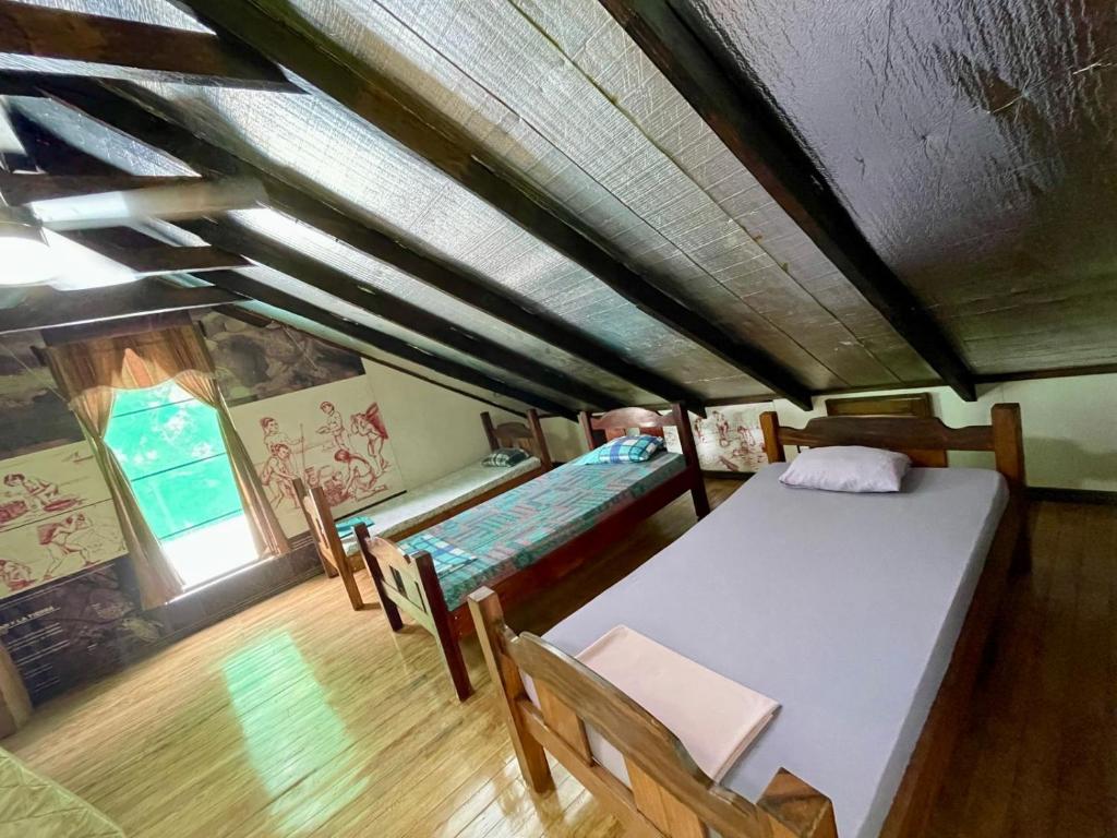 a room with two beds and a table and chairs at Habitacion Atico in Curubandé