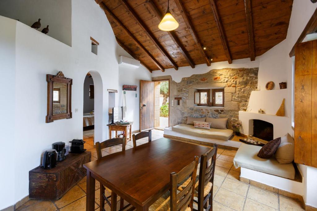 a living room with a wooden table and a fireplace at Tzokeika Traditional Settlement in Riglia