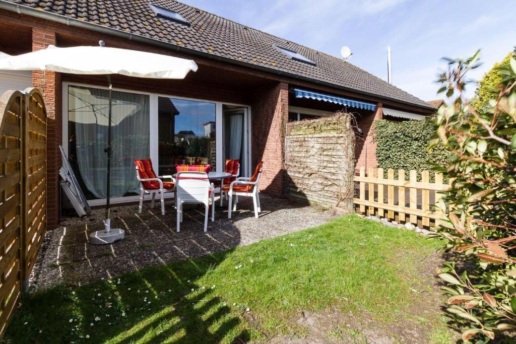 a patio with a table and chairs and an umbrella at Ferienwohnung-Mour in Dahme