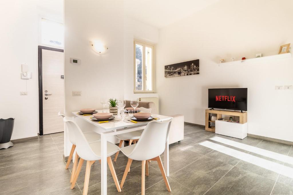 a white dining room with a white table and chairs at Malpensa sweet home in Busto Arsizio