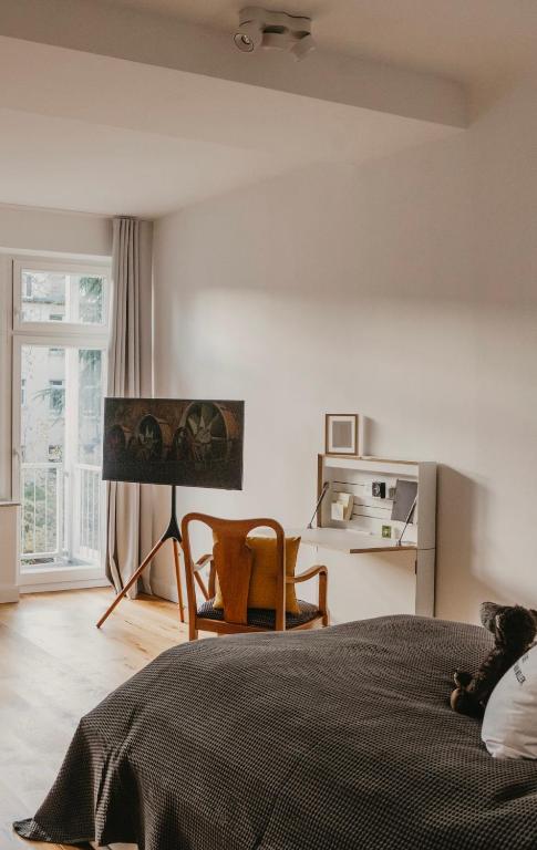 a bedroom with a bed and a chair and a window at Freytag im Uni-Viertel in Duisburg