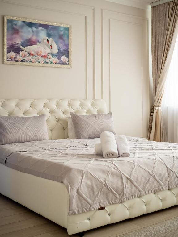 a white bedroom with a large white bed in it at Smart Lux 320 in Almaty