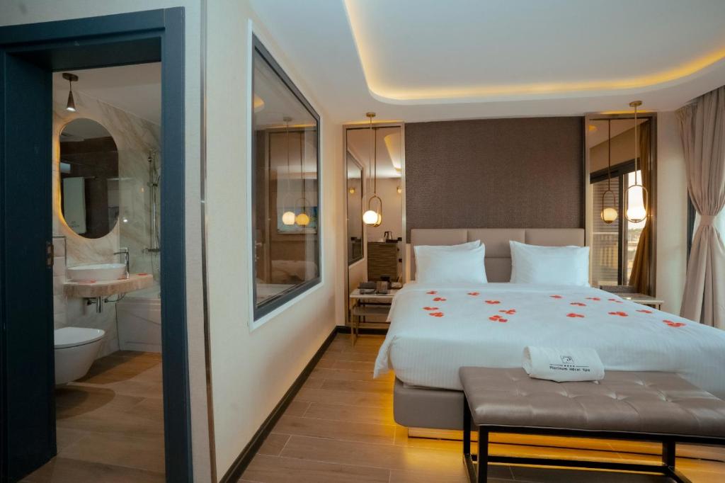 ein Schlafzimmer mit einem großen Bett und ein Badezimmer in der Unterkunft Platinum Hôtel Spa Abidjan Cocody in Abidjan