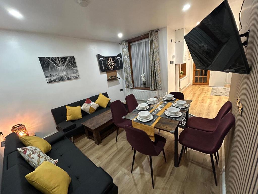 a living room with a black couch and a table at Minstead Houses - 5 Bedroom Contractor House Sleeps 9 Parking for 2 Vans Near Bromford Duddeston Fort Dunlop Star City HS2 in Birmingham