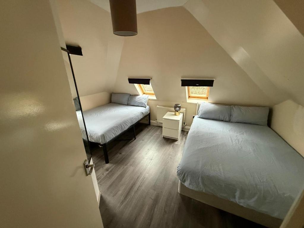 a small room with two beds and a window at Central London double bed apartment Free Parking Incl Stays upto 6 in London