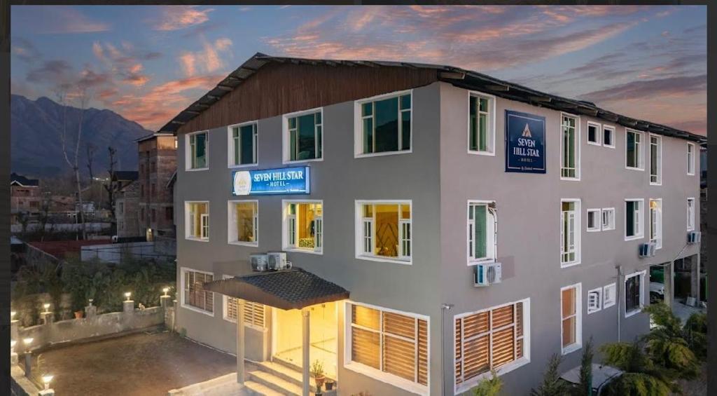 a large white building with a lot of windows at Hotel Seven Hill Star in Srinagar