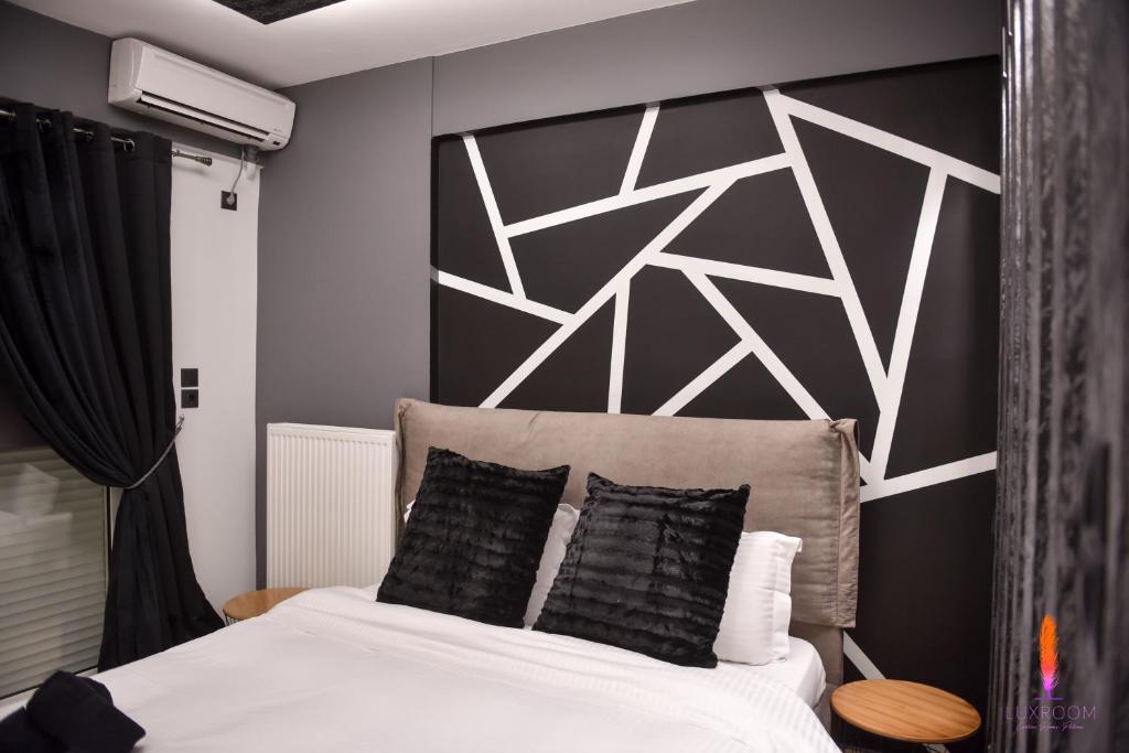 a bedroom with a bed with a black and white wall at LuxRoom in Patra