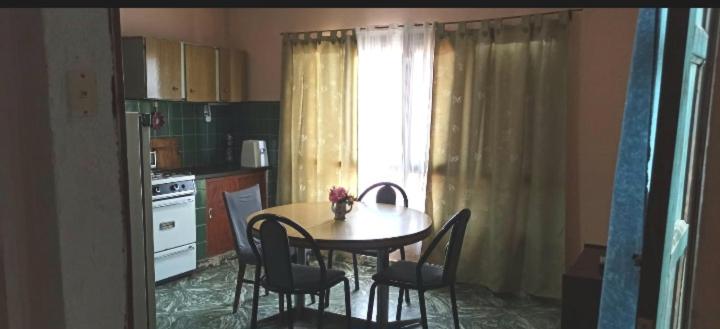 a kitchen with a table and chairs and a window at Graciana Quequén in Necochea