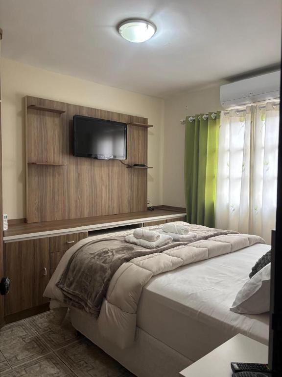 a bedroom with a bed with a flat screen tv at Casa no Roteiro do Vinho in São Roque