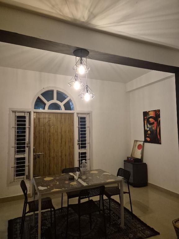 a dining room with a table and chairs and a window at Boho Rooms in Jorhat
