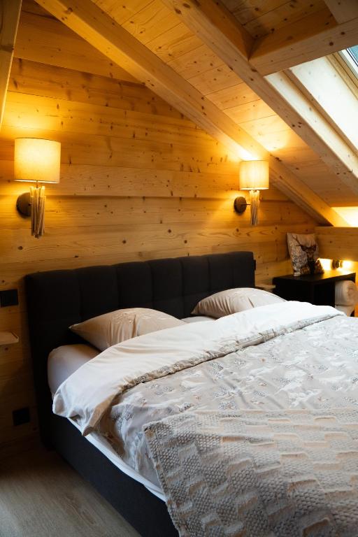 a bedroom with a large bed in a wooden ceiling at La Rose des neiges à Châtel in Châtel