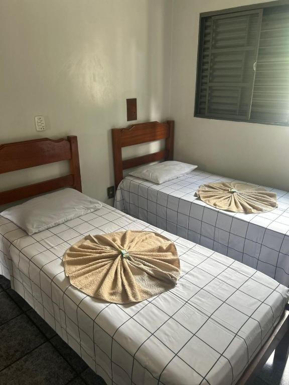 two beds with bows on them in a room at Hotel Ravena Araraquara in Araraquara