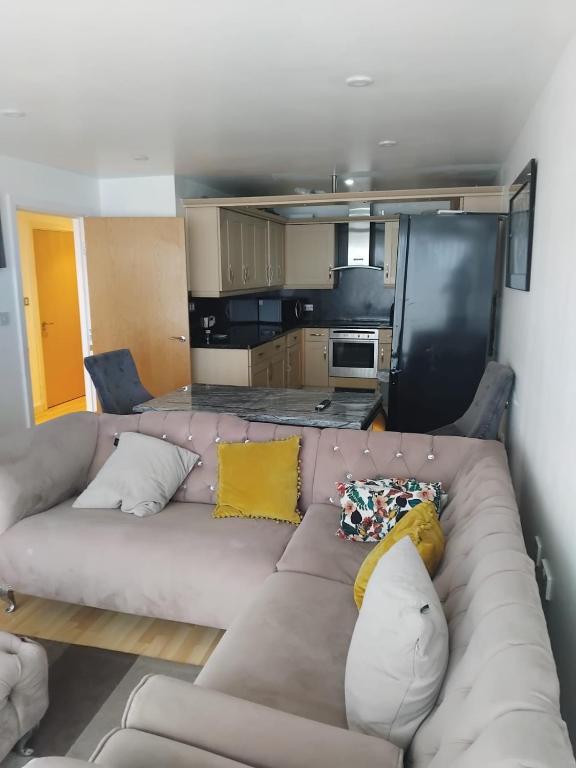 a living room with a couch and a kitchen at 2 Bedroom APARTMENT in Manchester