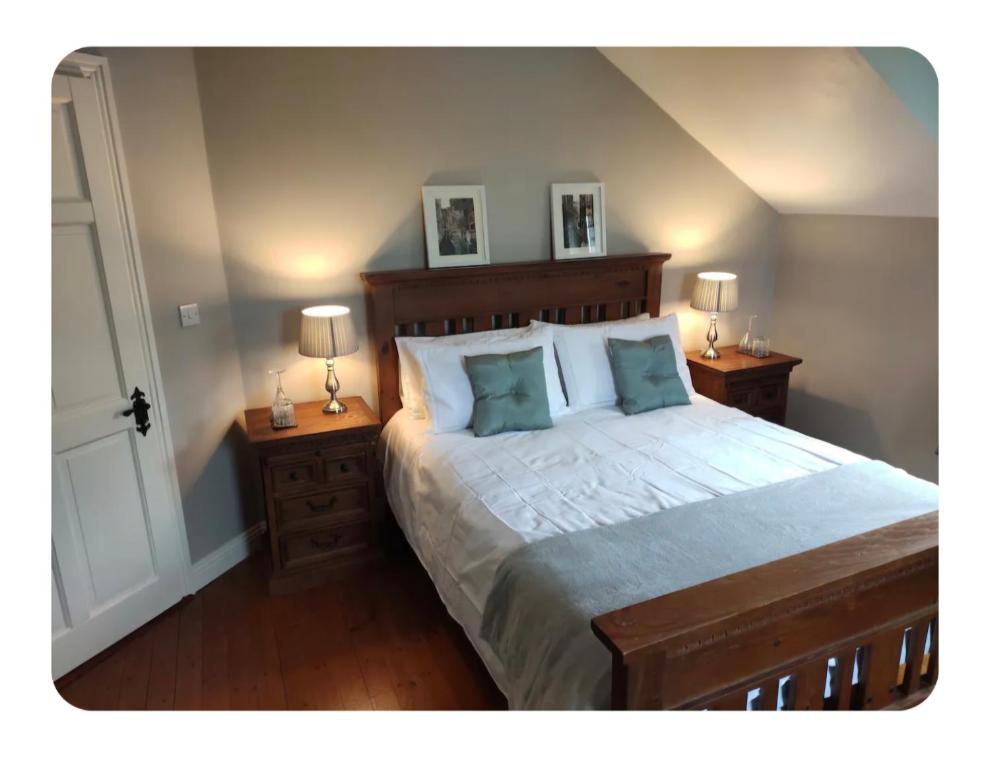 a bedroom with a large bed with two night stands at Dairy Guesthouse in Cappamore