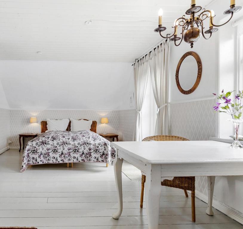 a white bedroom with a bed and a table at Villa Vendel B&B in Løkken