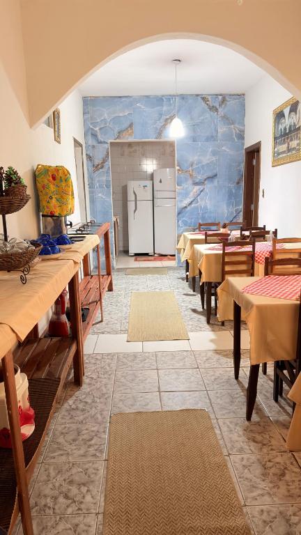 a dining room with wooden tables and a refrigerator at Pousada A CASA DE IRENE in Aparecida