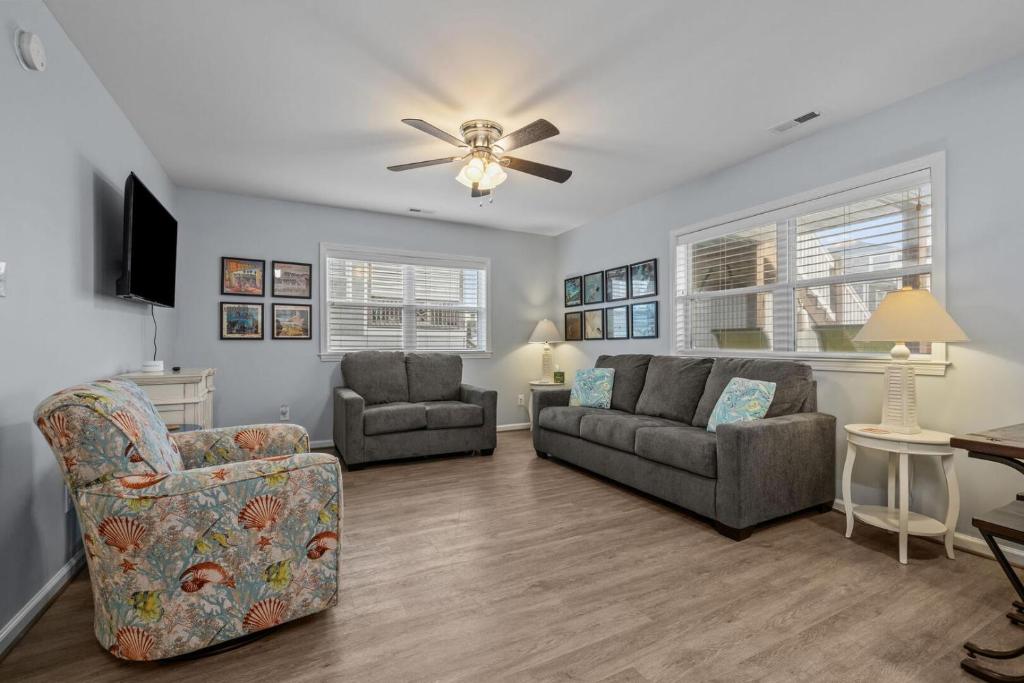 a living room with two couches and a ceiling fan at Boardwalk Shores D in Atlantic Beach