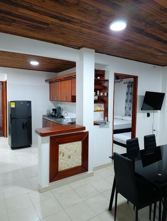 a kitchen with a counter and chairs in a room at Glamar Apartamento in Arboletes