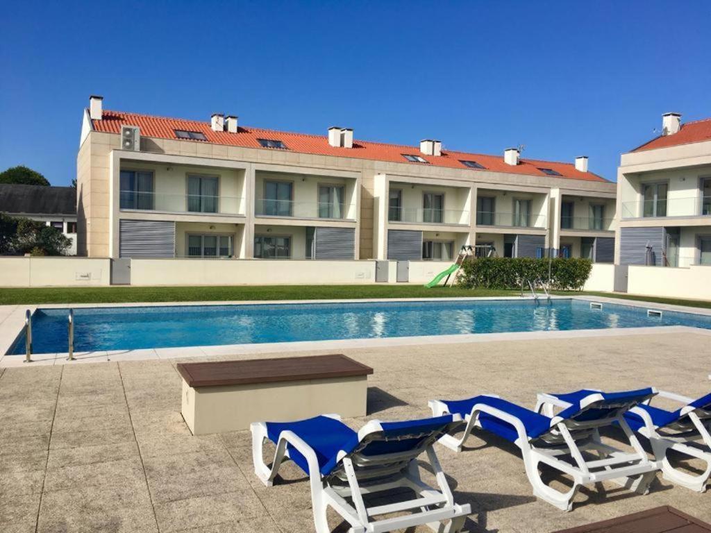 a group of lounge chairs and a swimming pool at SeaHorse House in Esposende