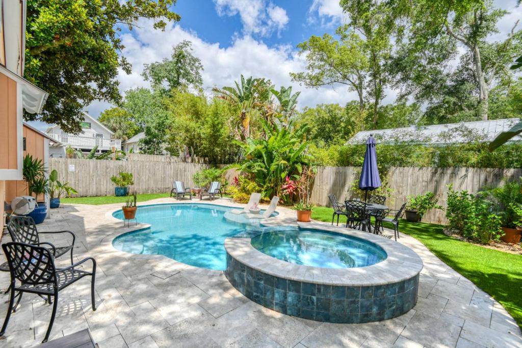 a swimming pool with a patio furniture and chairs around it at Mulberry Oasis in St. Augustine