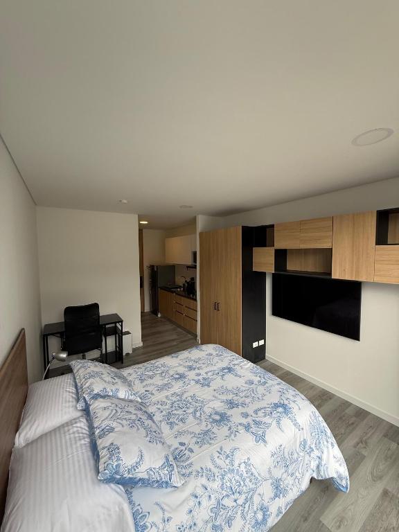 a bedroom with a bed with a blue and white bedspread at Aparta Suite Centro Internacional Edificio 33DC Piso 29 Estación Trasmilenio Calle 34 in Bogotá