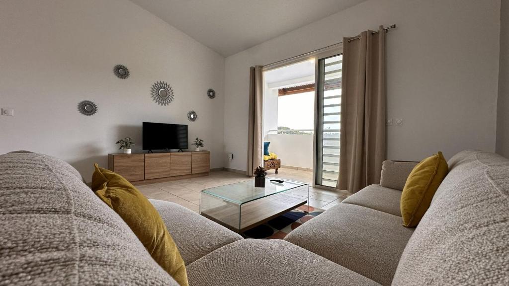 a living room with a couch and a tv at Vista - Route des plages - Destination Guyane in Rémire-Camp