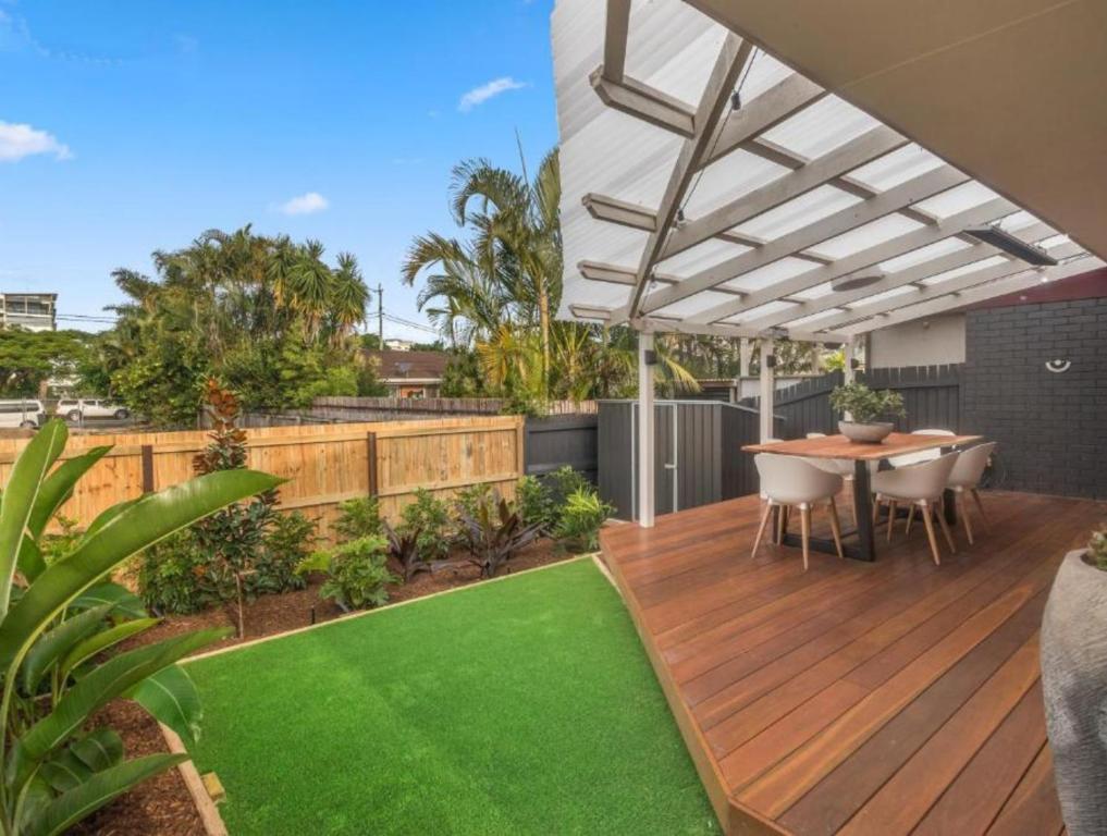 a deck with a table and chairs on a house at The Mooloolaba Gallery in Mooloolaba