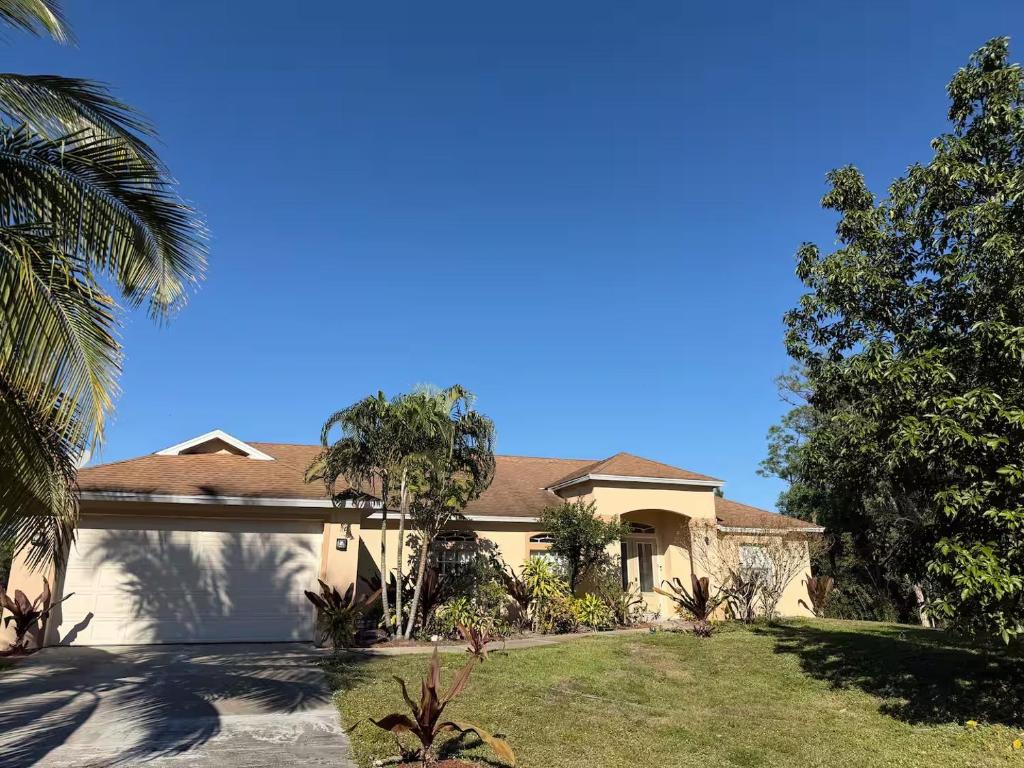 a house with a palm tree in the yard at Quiet Naples retreat suite with pool - 1 or 2 bedrooms in Naples