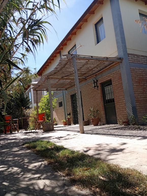 a house with a patio and a building at Casa Boreal dptos estilo casa in Puerto Madryn