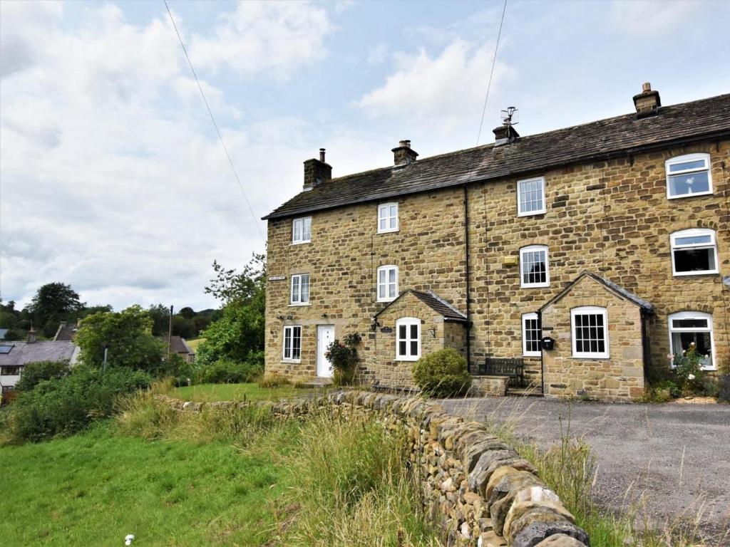 an old stone house with a stone wall at 2 Bed in Eyam oc-pk812 in Eyam