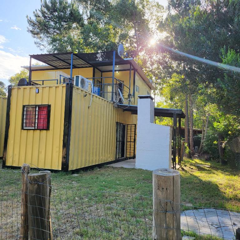 a large yellow house in the middle of a yard at Apartamento 2 Guazuvira in Guazuvira