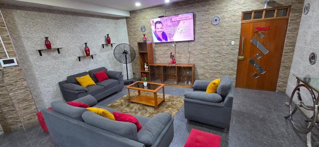 a living room with two couches and a tv at Ximena's House in Iquitos