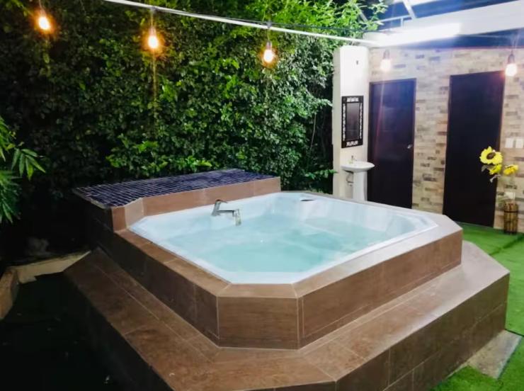 a large bath tub in a yard with plants at Villa Lourdes in Rousseau