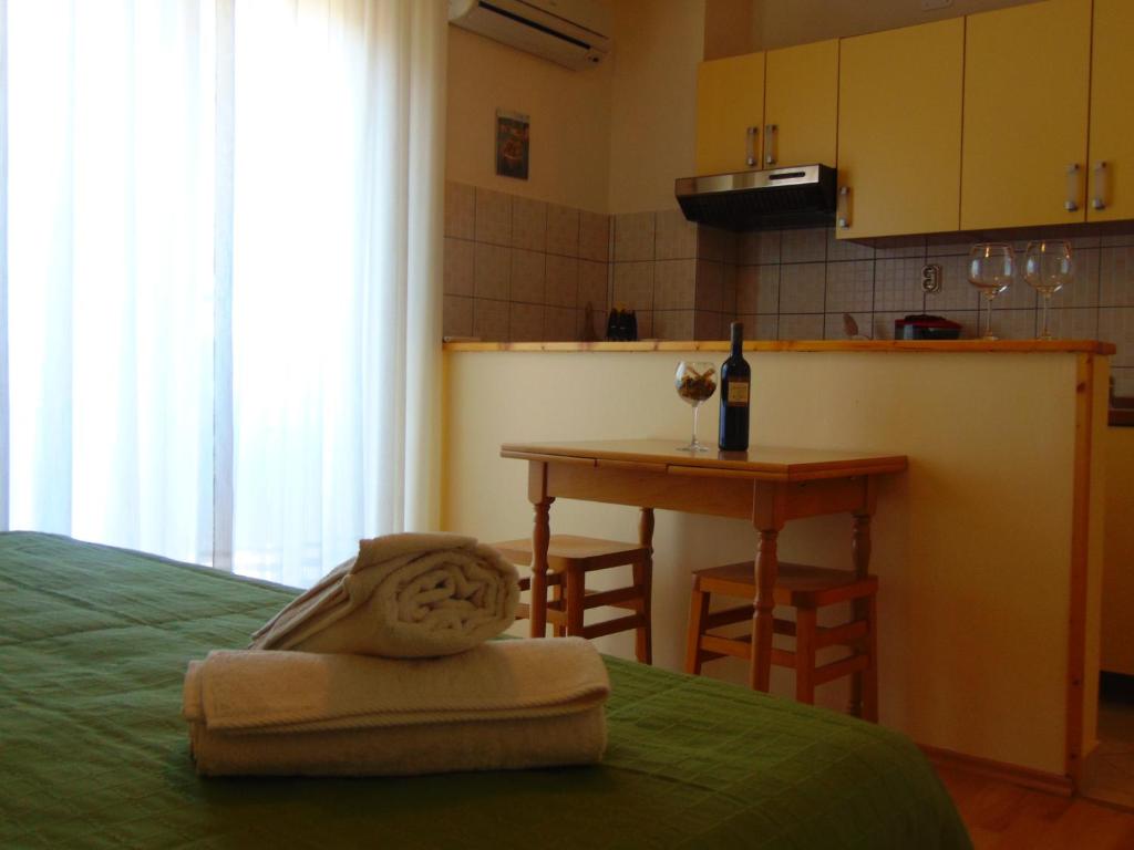 耶爾薩的住宿－耶爾薩旅館，一间卧室配有一张床和一张桌子及一瓶葡萄酒