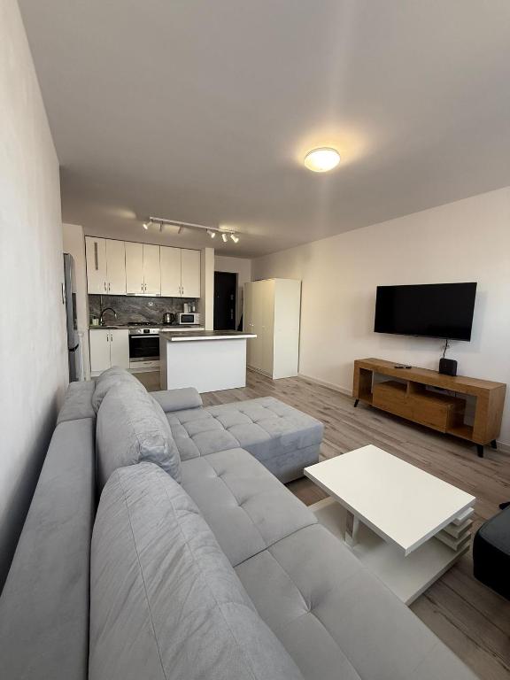 a living room with a sectional couch and a tv at Apartament Centrum nr 8 in Radom