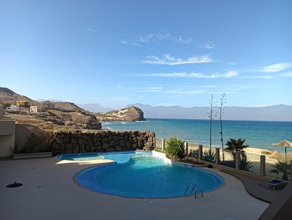 a swimming pool with a view of the ocean at Sol Lazareto Mindelo in Prainha