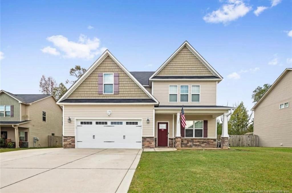 a large house with a white garage at The Bee & Bramble in Raeford