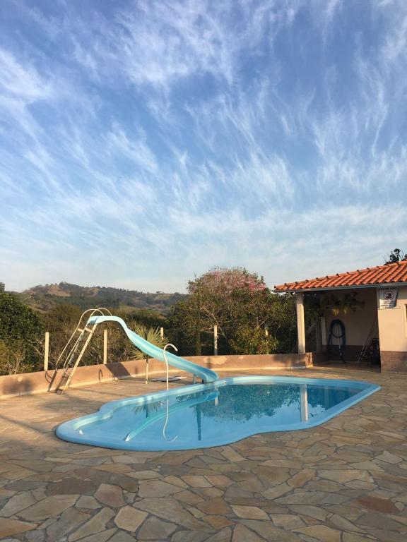 a pool with a water slide in a yard at Sítio primavera socorro-sp in Socorro