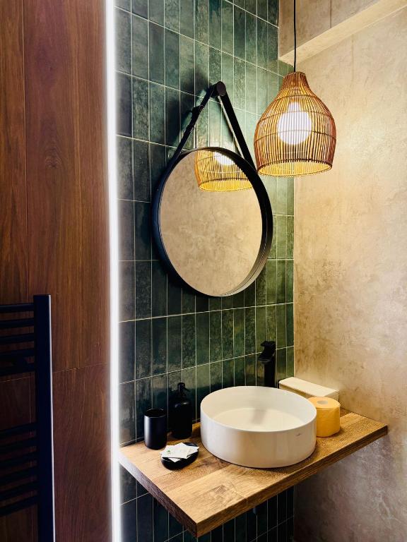 a bathroom with a sink and a mirror on a counter at Boutique Hotel Pui de Urs Fundata in Ciocanu